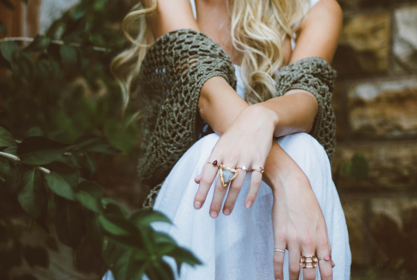 female_model_sitting_arms_crossed_wearing_jewelry